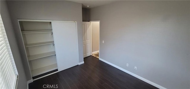 unfurnished bedroom featuring dark hardwood / wood-style flooring and a closet