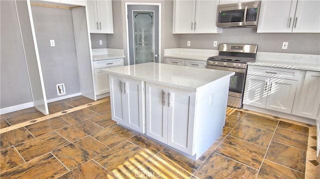 kitchen featuring stainless steel appliances, a kitchen island, and white cabinets