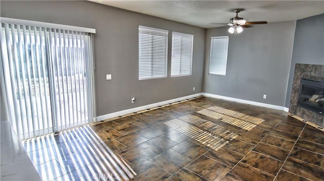 unfurnished living room featuring a tile fireplace and ceiling fan