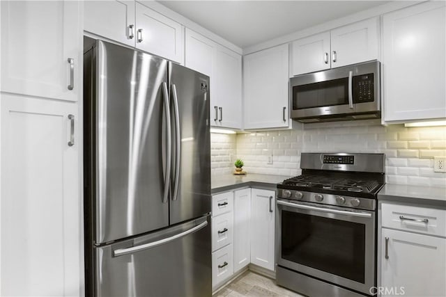 kitchen with backsplash, stainless steel appliances, and white cabinets