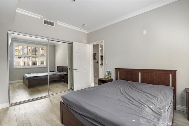 bedroom featuring crown molding, a closet, and light wood-type flooring