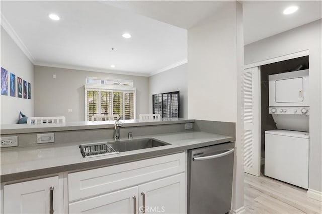 kitchen with white cabinetry, sink, stacked washer and clothes dryer, and dishwasher