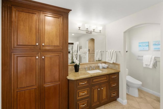 bathroom with tasteful backsplash, vanity, tile patterned floors, and toilet