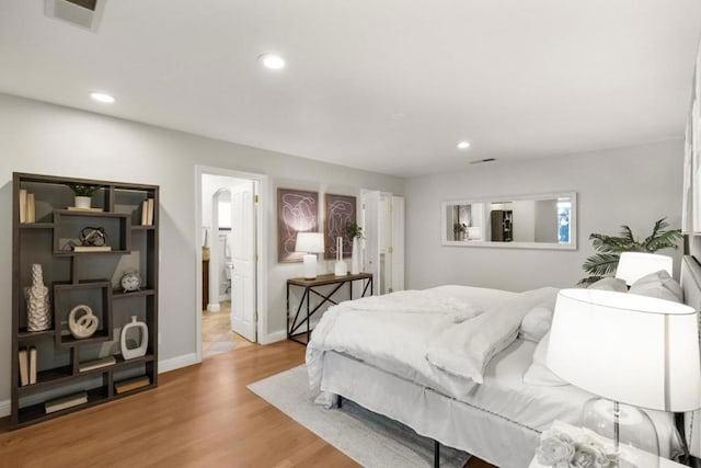 bedroom with fridge and light wood-type flooring