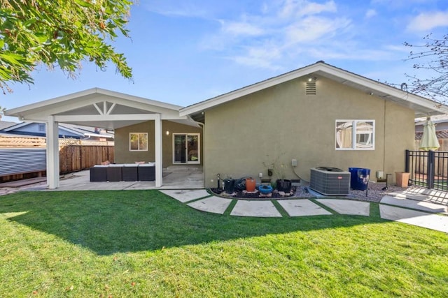 rear view of property featuring an outdoor living space, a lawn, central air condition unit, and a patio area