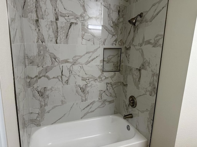 bathroom featuring tiled shower / bath