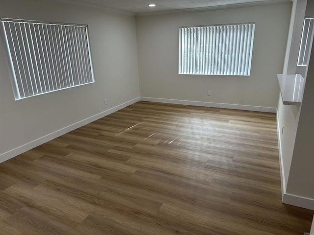 unfurnished room with wood-type flooring and crown molding