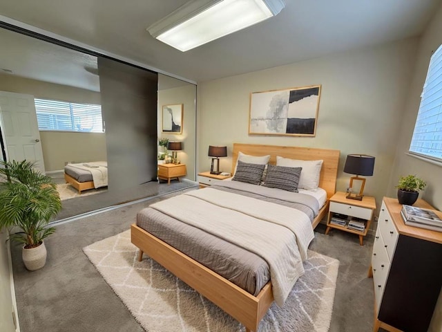 bedroom featuring dark carpet and multiple windows