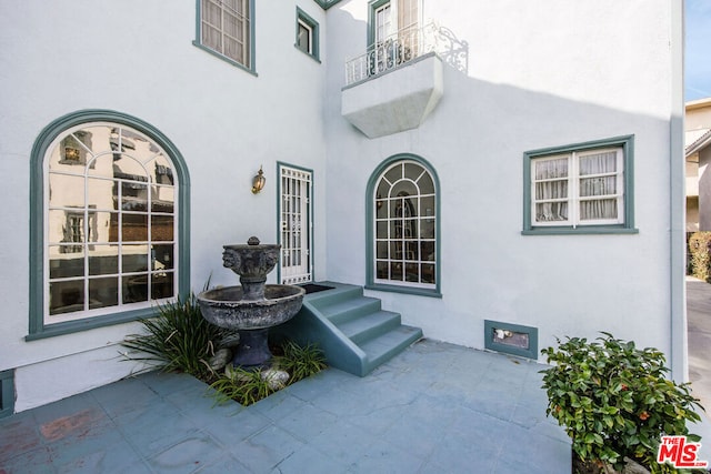 entrance to property with a patio area and a balcony