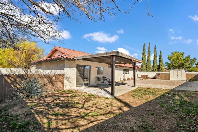 back of house with a patio and a storage unit