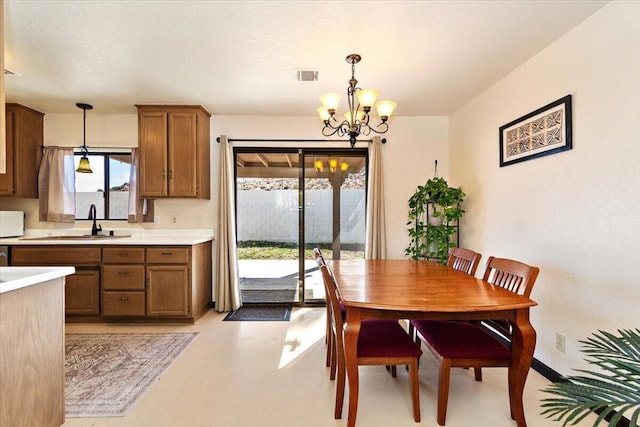 dining area with an inviting chandelier and sink