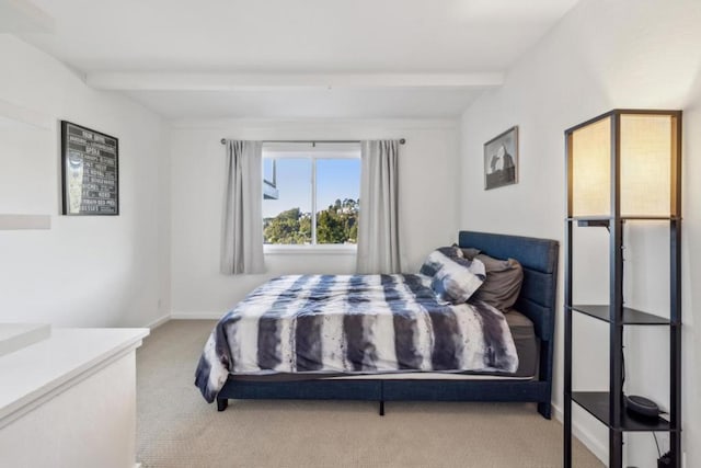 bedroom with beam ceiling and carpet