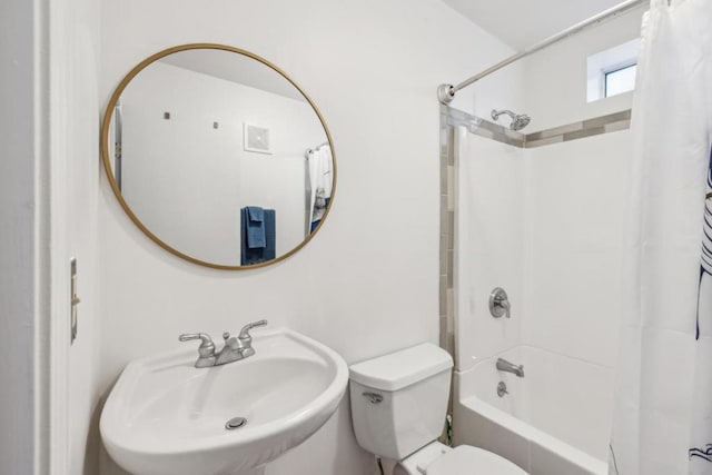 full bathroom featuring sink, shower / tub combo with curtain, and toilet