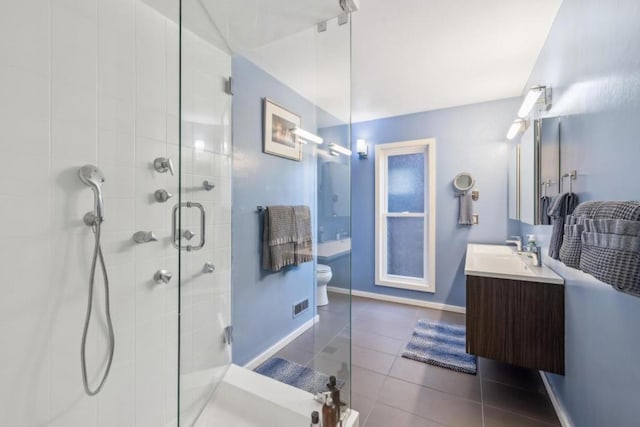 bathroom featuring vanity, toilet, tile patterned flooring, and a shower with door