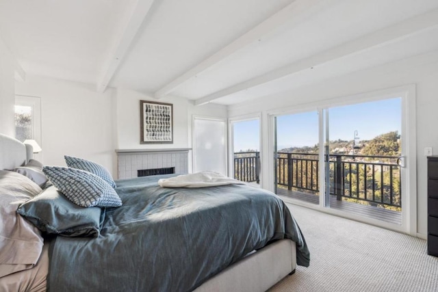 carpeted bedroom with access to exterior, beamed ceiling, and a brick fireplace