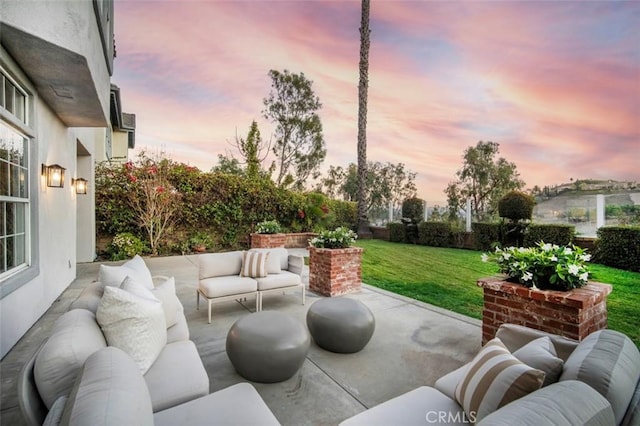 patio terrace at dusk with a yard and outdoor lounge area