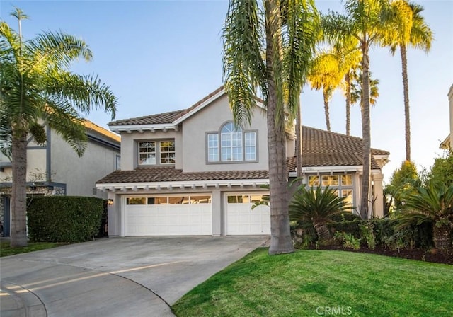 mediterranean / spanish house featuring a garage and a front lawn