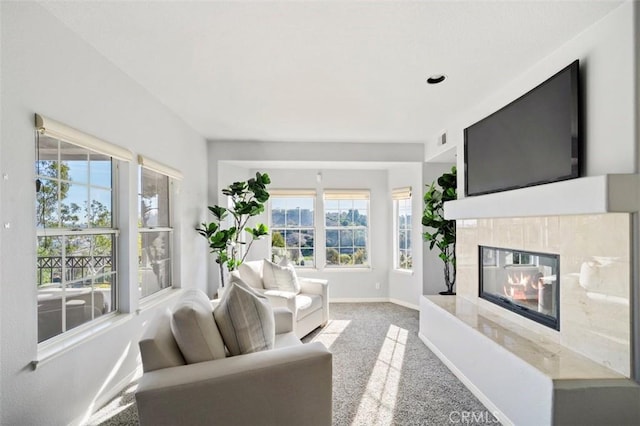 living room with a tiled fireplace and carpet flooring