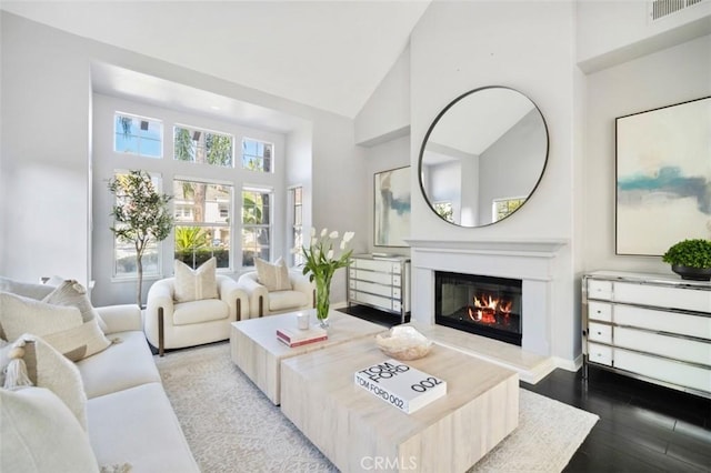 living room with high vaulted ceiling and light wood-type flooring