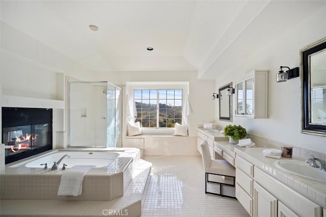 bathroom with vanity, tile patterned floors, and plus walk in shower