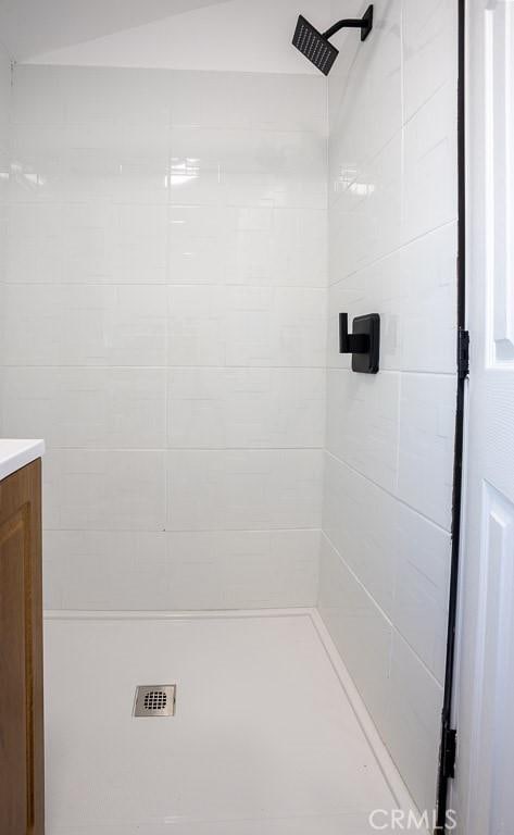 bathroom with vanity and a tile shower