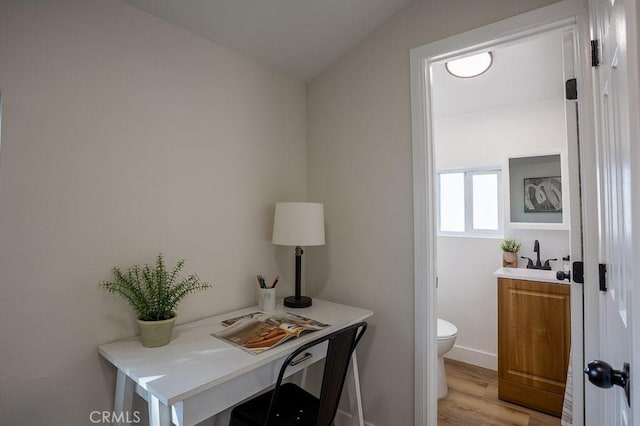 office area with sink and light hardwood / wood-style flooring