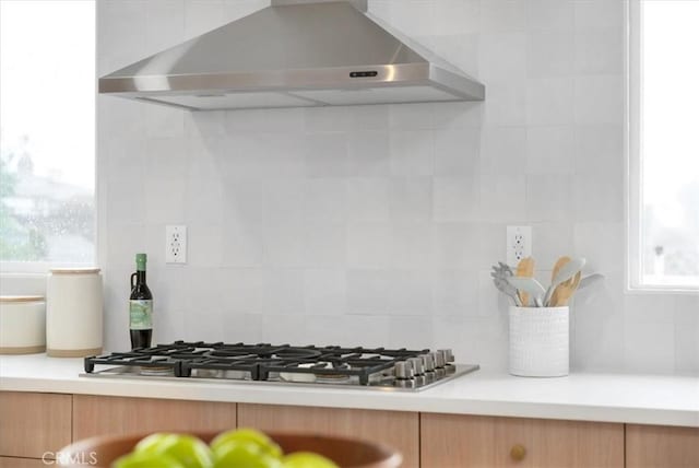 kitchen featuring decorative backsplash, ventilation hood, and stainless steel gas stovetop