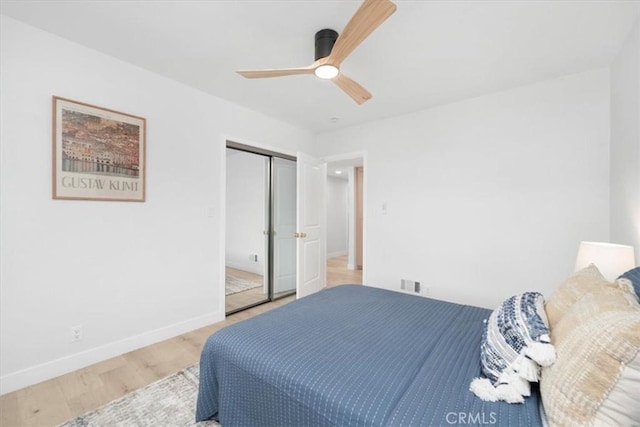 bedroom with hardwood / wood-style floors, a closet, and ceiling fan