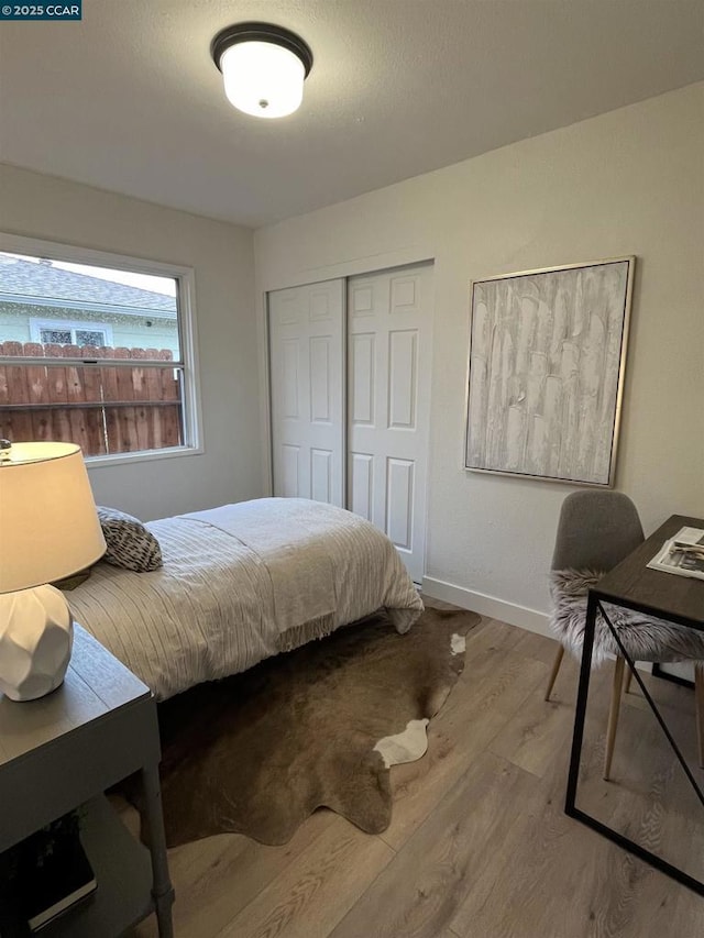 bedroom with wood-type flooring and a closet