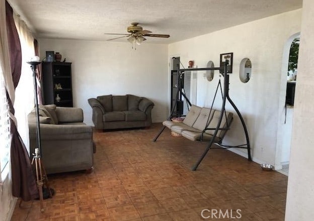 living room featuring a textured ceiling and ceiling fan