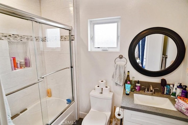 full bathroom with vanity, toilet, and combined bath / shower with glass door