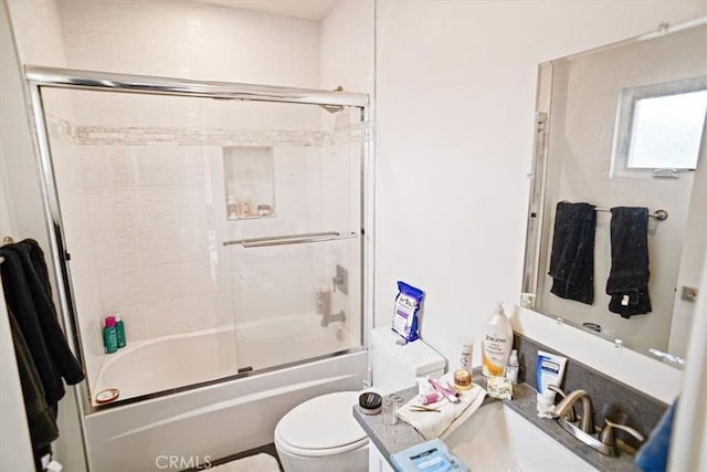 full bathroom with vanity, toilet, and combined bath / shower with glass door