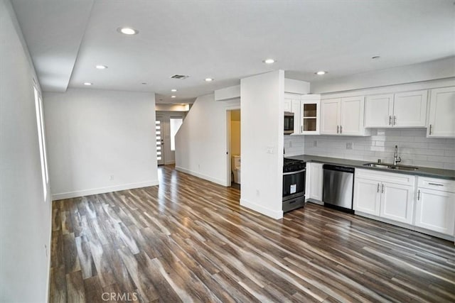 kitchen with sink, white cabinetry, tasteful backsplash, appliances with stainless steel finishes, and dark hardwood / wood-style flooring