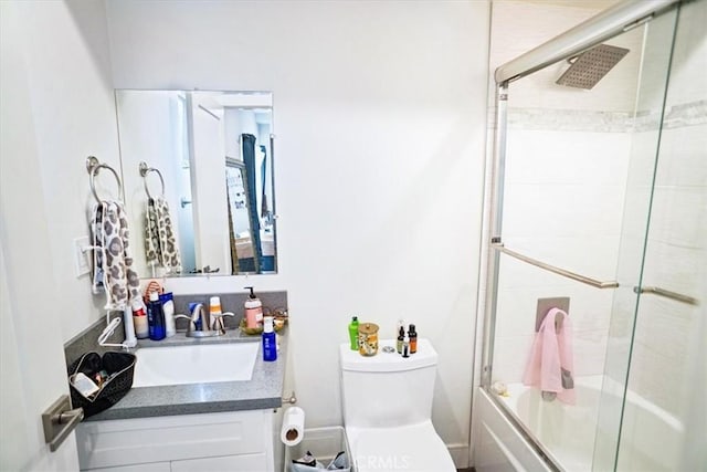 full bathroom featuring enclosed tub / shower combo, vanity, and toilet