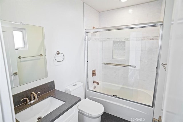 full bathroom with toilet, vanity, and bath / shower combo with glass door