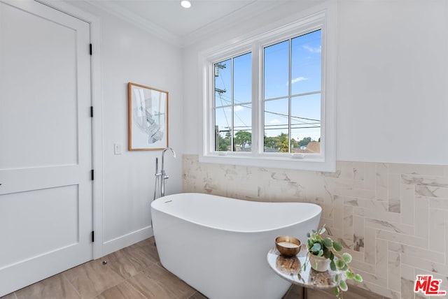 bathroom featuring crown molding, a bath, and tile walls