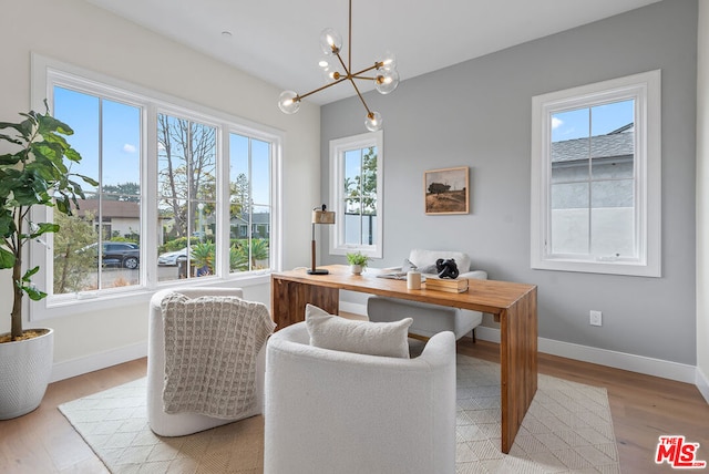 office space with an inviting chandelier and light wood-type flooring