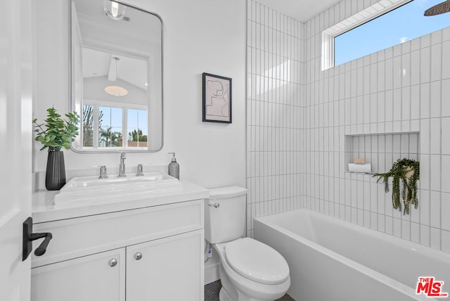 full bathroom featuring a healthy amount of sunlight, toilet, tiled shower / bath combo, and vanity