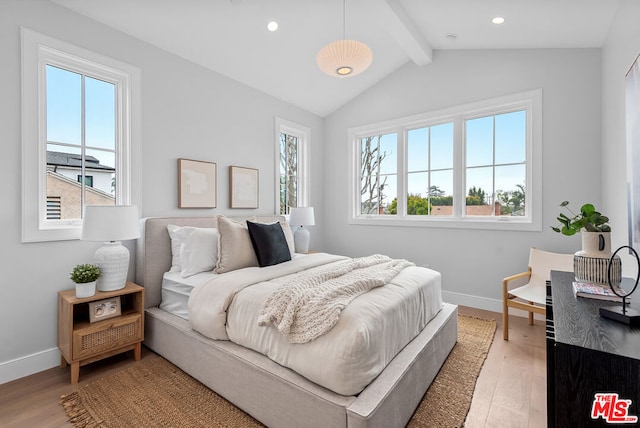 bedroom with multiple windows, vaulted ceiling with beams, and light hardwood / wood-style floors