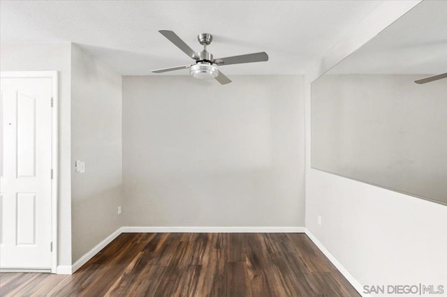 spare room featuring ceiling fan and dark hardwood / wood-style flooring