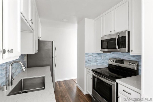 kitchen featuring sink, white cabinets, dark hardwood / wood-style flooring, decorative backsplash, and stainless steel appliances