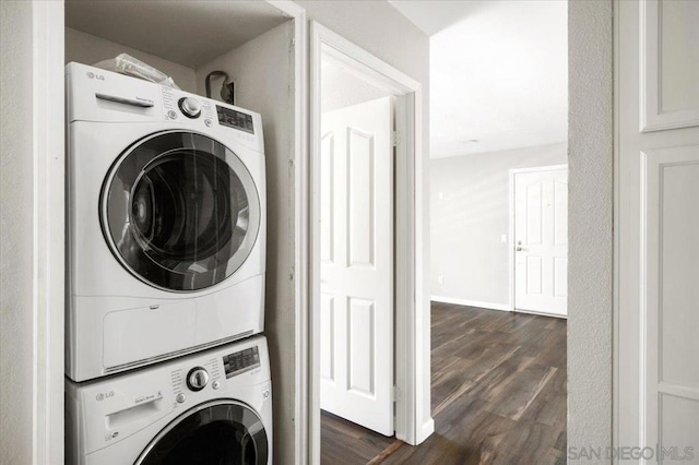 washroom with dark hardwood / wood-style floors and stacked washer and clothes dryer