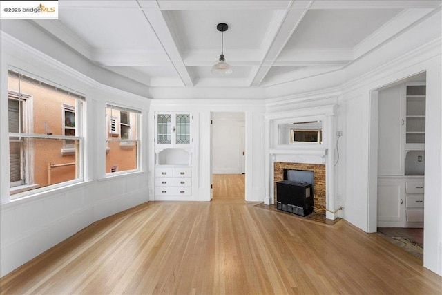 unfurnished living room with hardwood / wood-style flooring, coffered ceiling, and beam ceiling