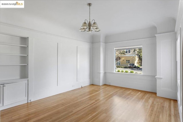 interior space featuring a notable chandelier, hardwood / wood-style flooring, and built in features