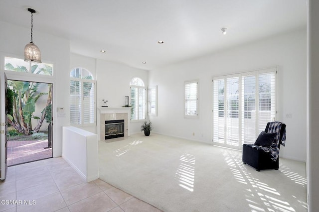 interior space featuring a tile fireplace and light carpet