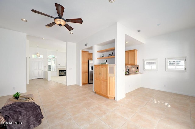 kitchen featuring light brown cabinetry, stainless steel fridge, ceiling fan, and light tile patterned flooring