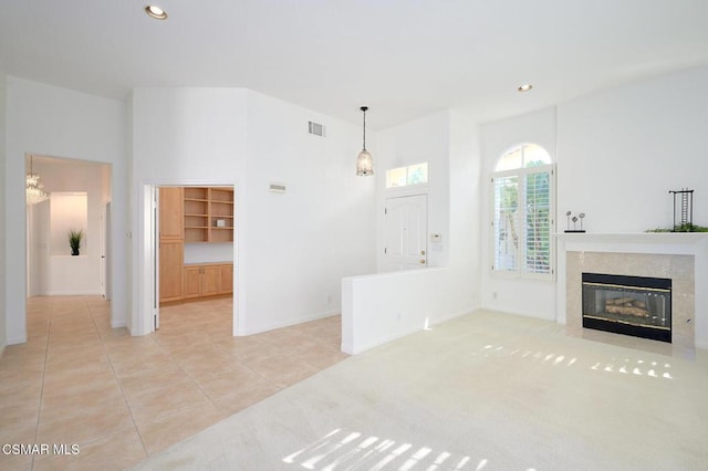 living room with light colored carpet, a high end fireplace, and a high ceiling