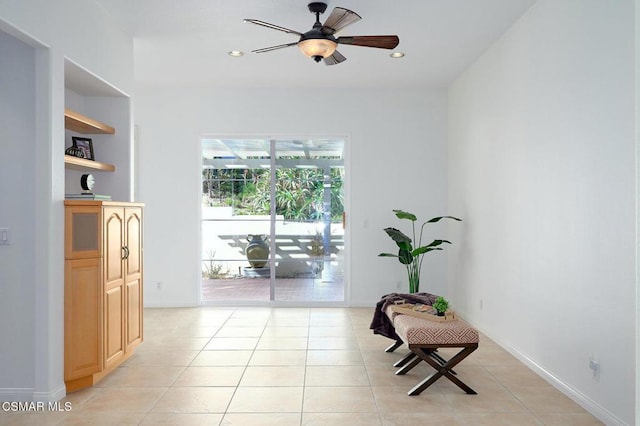 living area featuring light tile patterned floors and ceiling fan