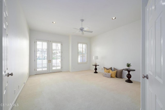 sitting room with french doors, ceiling fan, and light carpet