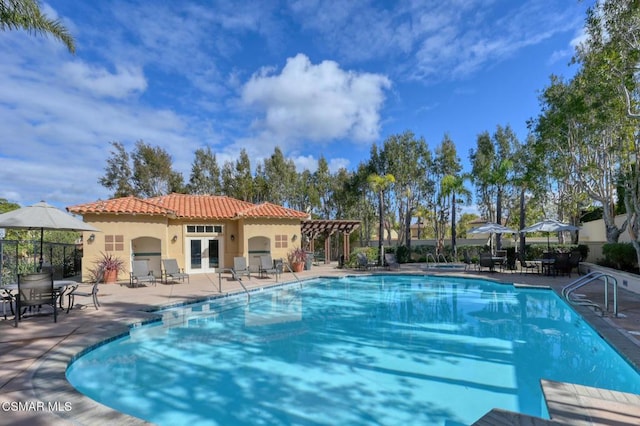 view of swimming pool featuring french doors, a pergola, and a patio